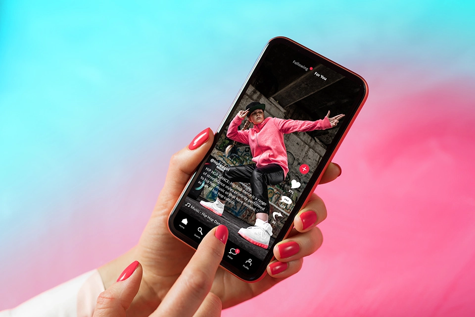 Someone holding a phone with TikTok on it showing an example of creator licensing