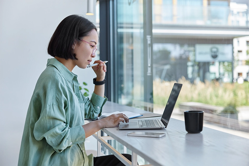 Woman on a laptop wondering how to choose a CRM