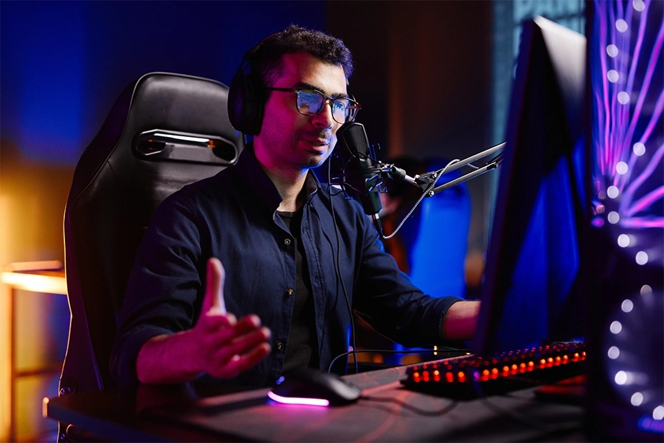 Twitch influencer marketing means working with Twitch streamers like this one sitting at a computer desk speaking into a mic