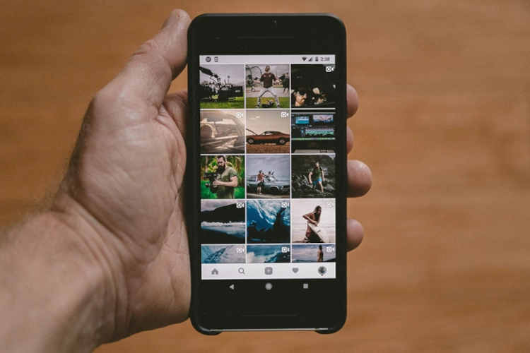 hand holding a cell phone with videos showing user-generated content rights potential issues